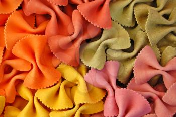 Four different flavors of farfalle bow ties pasta. Italian food background detail.