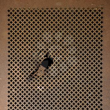 Rusty perforated metal surface. Worn iron grille background texture.