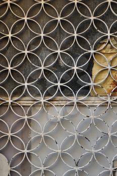 Rusty metal door with geometric circles motif and paint stained glass background.