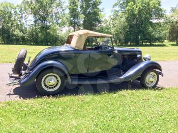 1934 Ford Roadster blue in park on green grass outdoor sky