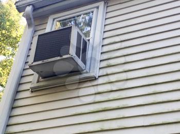 Air conditioner window unit with moldy on vinyl siding on house