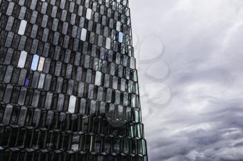 The building features a distinctive colored glass facade inspired by the basalt landscape of Iceland.