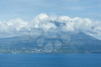 Mountain of PIco with clouds forming around its peak, a view from Faial, Azores, Portugal