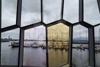Reykjavik, Iceland - 17 June 2014: View of Reykjavik harbor through Glass walls of Harpa concert hall from inside the building