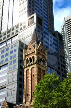 Bell tower of St-Michael uniting church with business buildings in background in Melbourne, Australia
