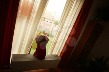 Royalty Free Photo of a Little Girl Looking Out the Window