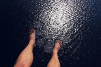 Royalty Free Photo of a Persons Feet Over Water