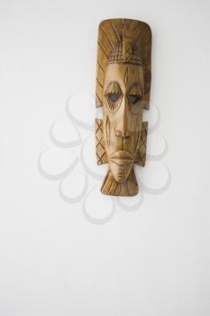 A wooden ceremonial mask on a white background.