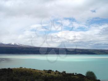 Royalty Free Photo of Water and Mountains in the Distance on a Cloudy Day