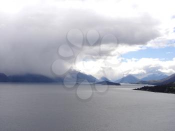 Royalty Free Photo of Cloud Covered Mountains and Water