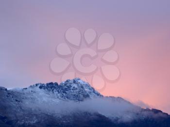 Royalty Free Photo of A Snowcapped Mountain Against a Pink Twilight Sky