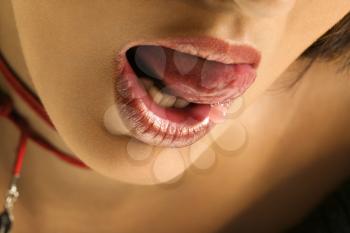 Royalty Free Photo of a Close-up Portrait of a Young Woman Licking Her Lips