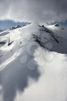 Aerial of snow covered mountain with clouds in Crystal Range, California, USA.