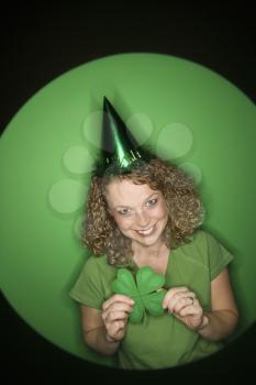 Royalty Free Photo of a Woman Wearing a Party Hat and Holding a Shamrock