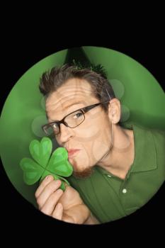 Royalty Free Photo of a Vignette of a Man Wearing a Saint Patrick's Day Hat and Kissing a Shamrock