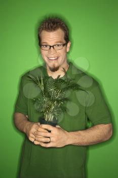Royalty Free Photo of a Smiling Man Holding a Plant