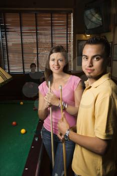 Royalty Free Photo of a Young Man and Woman Smiling While Playing Billiards
