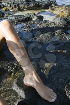 Royalty Free Photo of a Leg and Foot of a Young Female on Rocks on a Beach in Maui Hawaii