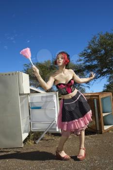 Royalty Free Photo of a Woman House Cleaning in a Junkyard