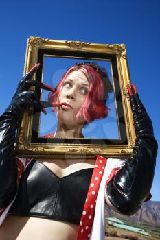 Royalty Free Photo of a Woman Holding an Empty Frame to Her Face