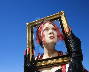 Royalty Free Photo of a Woman Holding an Empty Frame Around Her Head