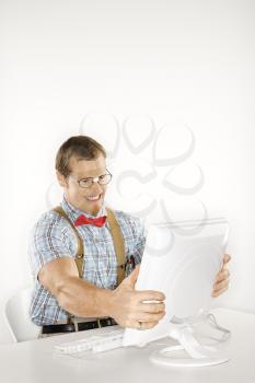 Royalty Free Photo of a Man Dressed Like a Nerd Holding a Computer Monitor in Frustration