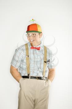Royalty Free Photo of a Nerdy Man Wearing a Propeller Cap With Hands in His Pockets Smiling