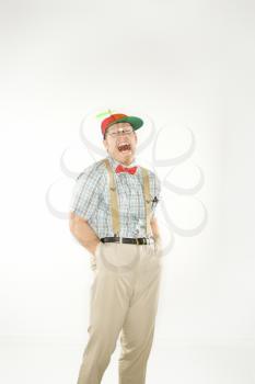 Royalty Free Photo of a Nerdy Man Wearing a Propeller Cap With Hands in His Pockets Smiling