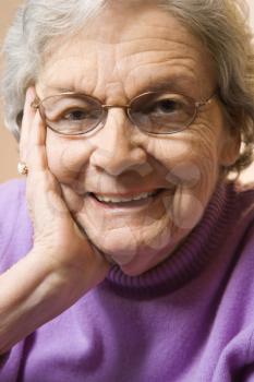 Royalty Free Photo of an Elderly Woman Smiling With Hand on Face