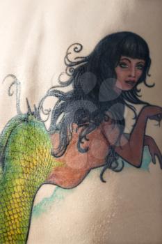 Royalty Free Photo of Close-up of a Woman's Back With a Mermaid tattoo
