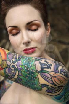 Royalty Free Photo of a Close-up of an Attractive Woman's Face and Tattooed Arm