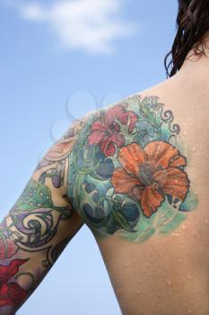 Royalty Free Photo of a Close-up of a Woman's Back and Shoulder Covered With Floral Tattoos