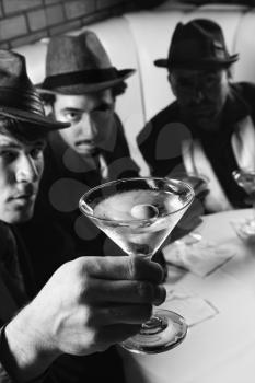 Royalty Free Photo of Three Men Sitting in a Bar With Martinis 