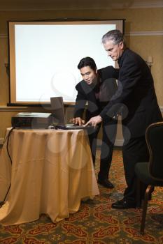 Royalty Free Photo of a Businessman Helping Another Businessman Give a Presentation