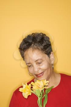 African American mature adult female holding flowers.