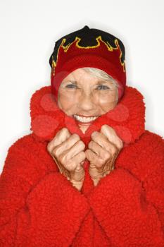 Royalty Free Photo of an Older Woman Wearing a Coat and a Flame Hat
