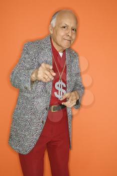 Royalty Free Photo of an Older Male Wearing a Money Sign Necklace and Pointing