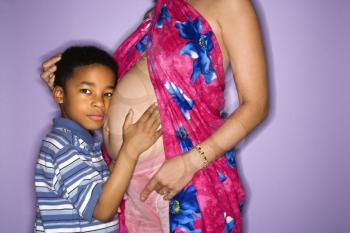 Royalty Free Photo of a Pregnant Woman With Her Son  Listening to Her Stomach