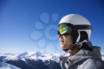 Royalty Free Photo of a Teenage Boy Snowboarder Wearing a Helmet and Goggles on a Mountain