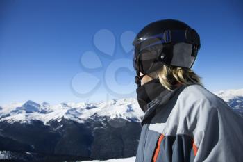 Royalty Free Photo of a Teenage Boy Snowboarder Wearing a Helmet and Goggles on a Mountain