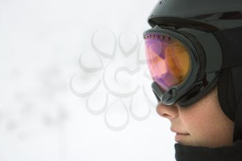 Royalty Free Photo of Profile of a Teenage Boy Skier Wearing a Helmet and Goggles at a Ski Resort on a Mountain