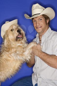 Royalty Free Photo of a Man and a Dog Wearing Cowboy Hats
