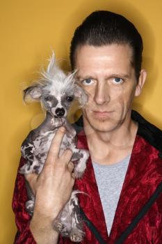 Royalty Free Photo of a Male Wearing Velvet and Holding a Chinese Crested Dog