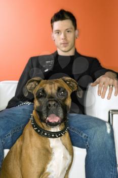 Royalty Free Photo of a Man Sitting With a Boxer Dog
