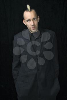 Royalty Free Photo of a Man in a Suit With Mohawk Against a Black Background