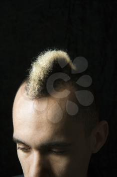 Royalty Free Photo of a Man in a Suit With Mohawk Against a Black Background