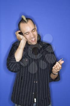 Royalty Free Photo of a Man Smiling Listening to Headphones Holding a CD 