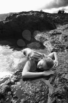 Royalty Free Photo of a Woman Lying Face Down on Rocks
