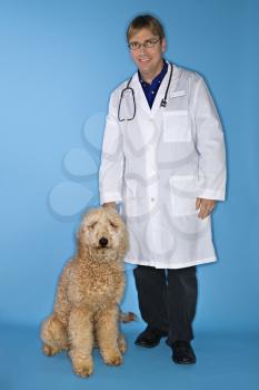 Royalty Free Photo of a Male Veterinarian With a Golden Doodle Dog