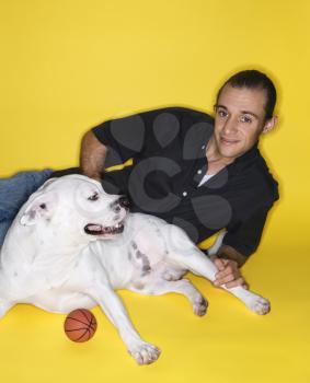 Royalty Free Photo of a Young Male Lying With a White Pit Bull Dog